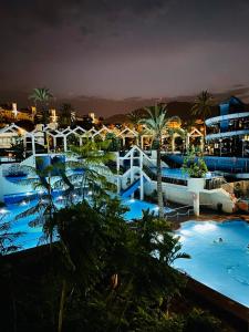 vista para uma piscina num resort à noite em Estudios y Apartamentos Benal Beach em Benalmádena