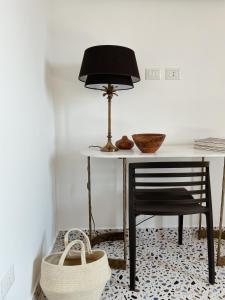 un tavolo con una sedia, una lampada e un cesto di Attico Pacifico a Ercolano