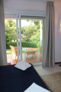 een slaapkamer met een grote glazen schuifdeur naar een patio bij Appartamenti in villa con piscina in Marina dʼAndora