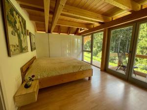 Un dormitorio con una cama en una habitación con ventanas. en Apartments in Blockhaus im Wald, en Siegsdorf