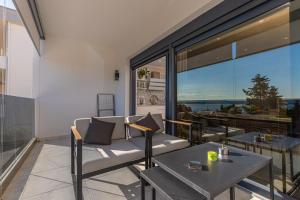 a patio with a couch and tables on a balcony at Apartment Rippl II in Crikvenica