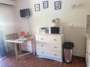 a kitchen with a desk and a microwave on a dresser at Studio Mag'Aline in Saint-Cyr-sur-Mer