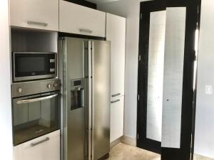 a kitchen with a stainless steel refrigerator and a microwave at Oceanview Luxury, Pool, Near Tour Boats & Beach in Puerto Vallarta