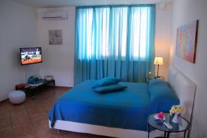 a bedroom with a blue bed and a television at B&B Darsena in Pozzuoli