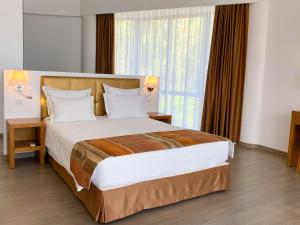 a bedroom with a large bed with a large window at Foz Club - Algarve in Alvor