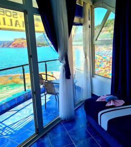 een slaapkamer met een raam met uitzicht op de oceaan bij Malibu Apartments in Sutomore