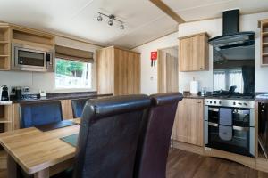 a kitchen with a wooden table and a dining room at Ruapehu Lodge in Aviemore
