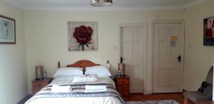 a bedroom with a bed and a red rose on the wall at Newlands Lodge in Kilkenny