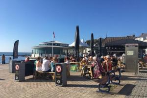 a group of people sitting at tables on a street at Large 5 bed town-centre home close to the beach, sleeps 9 in Aberystwyth