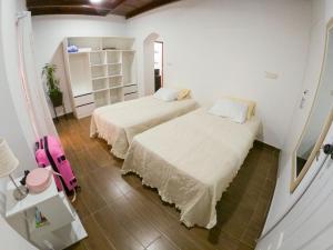 タラポトにあるNature & Travelersのベッドルーム1室(ベッド2台、ピンクのスーツケース付)