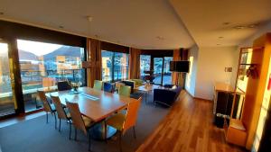 a dining room with a table and chairs and a living room at Havila Hotel Ivar Aasen in Ørsta