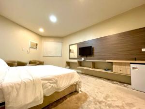 a bedroom with a bed and a flat screen tv at Relax Day Hotel in Tabuk