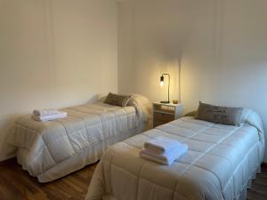 duas camas num quarto de hotel com toalhas em South Apartments em El Calafate