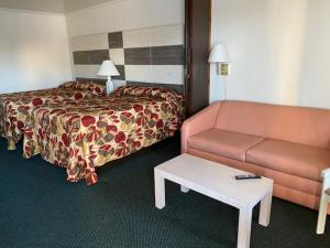 a hotel room with a bed and a couch at Fish Tales Boardwalk Inn & Ocean Mecca Motel in Ocean City