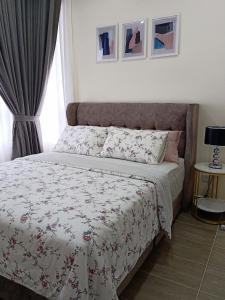 a bedroom with a bed with a floral bedspread at Al Zahra Homestay by Troika Kota Bharu in Kota Bharu