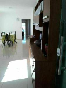 a kitchen with brown cabinets and a dining room at Recanto Concha Marinha in Prado