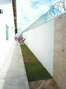 a white wall with a net on the side of a building at Recanto Concha Marinha in Prado +1 photo