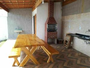 a wooden table in a kitchen with a brick oven at Recanto Concha Marinha in Prado