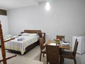 a bedroom with a bed and a table and chairs at Hospedagem Elite térreo in Cunha