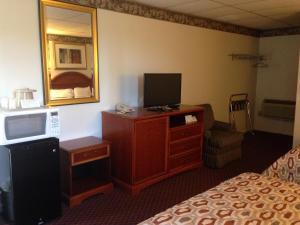 a hotel room with a bed and a television on a dresser at Americas Best Value Inn - Palmyra/Hershey in Palmyra