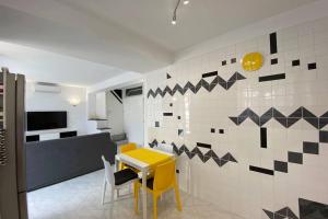 a dining room with a yellow table and chairs at I Limoni Capri Apartment in Capri