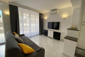 a living room with a couch and a television at I Limoni Capri Apartment in Capri