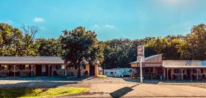 un viejo edificio con un cartel delante en Reel Inn and Lodge, en Quitman