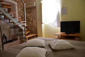 a bedroom with a bed with pillows and a television at Holiday Homes Susak Sansego in Susak