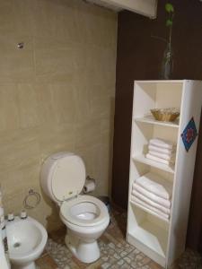 a bathroom with a toilet and a sink and towels at Casa Patagónica Los Charitos in El Chalten +32 photos