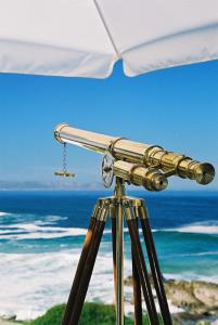 a camera on a tripod in front of the ocean at Pelagus Guest House in Hermanus