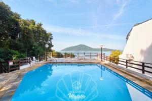 ウバトゥバにあるFrente pro MAR, linda VISTA, com piscina e 2 Suítes, no centro de Ubatuba, RECANTO 4の水辺の景色が見えるプール