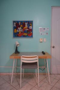 a desk with a chair and a painting on the wall at Casa Azul - Apartment in San Felipe de Puerto Plata