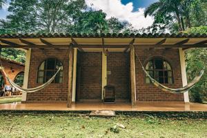 a small brick house with a porch and a chair at Huingos Eco Lodge in Tarapoto