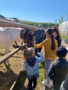 een groep kinderen en een man met een paard bij Hobby Land Ranch Horse's barn guesthouse in Găneasa