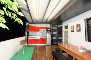 eine Küche mit roten Schränken und einem Holztisch in der Unterkunft 哦耶Oh Yeah 包棟民宿 in Luodong