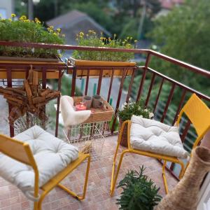 balkon z 2 krzesłami i stołem z roślinami w obiekcie Casa Fiorita 22 Porto Ceresio w mieście Porto Ceresio +33 zdjęcia