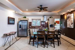 タマリンドにあるLUXURY 3BR appt, CENTER, 2 min to BEACH, hi-speed wifiのテーブルと椅子と冷蔵庫のあるキッチン