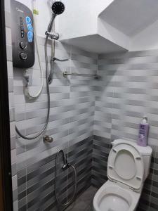 a bathroom with a shower and a toilet at Kayangan Inn in Rantau Panjang