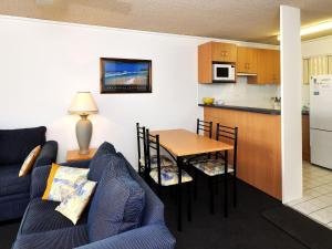 uma sala de estar e cozinha com um sofá e uma mesa em Providence Apartment 3 em Hawks Nest