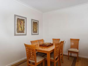 a dining room with a wooden table and chairs at Three Bedroom Townhouse in Hawks Nest