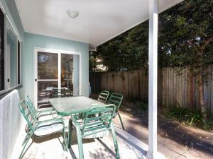 a green table and chairs on a patio at Three Bedroom Townhouse in Hawks Nest