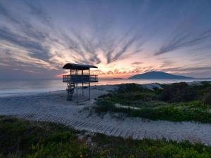 a lifeguard stand on a beach with a sunset at Three Bedroom Townhouse in Hawks Nest