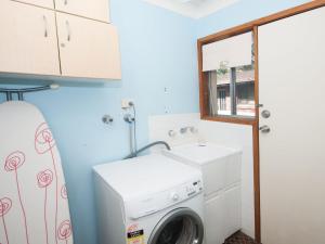 a laundry room with a washing machine and a window at Brilliant Location in Tea Gardens