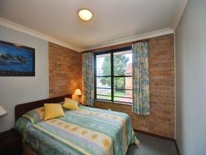 a bedroom with a bed and a window at Close To The Main Surf Beach in Hawks Nest