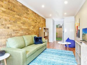 a living room with a couch and a brick wall at Tilly and Annies Place in Hawks Nest