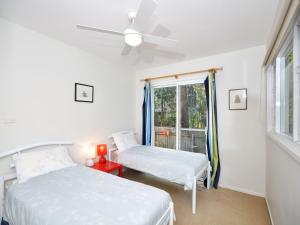 two beds in a room with a window at Ocean Nest Pet Friendly in Hawks Nest