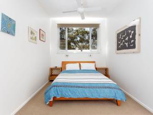 a bedroom with a bed and a window at Gumbeachy Pet Friendly Free WiFi in Hawks Nest