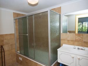 a bathroom with a glass shower and a sink at 4 Rio Vista in Hawks Nest +7 photos