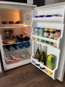 an open refrigerator filled with lots of food and drinks at Komfortný apartmán s bazénom a súkromným parkoviskom - 24h self check-in in Banská Bystrica