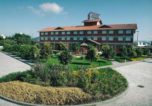 un gran edificio con un jardín delante de él en Hotel Estação 101 - Brusque, en Brusque